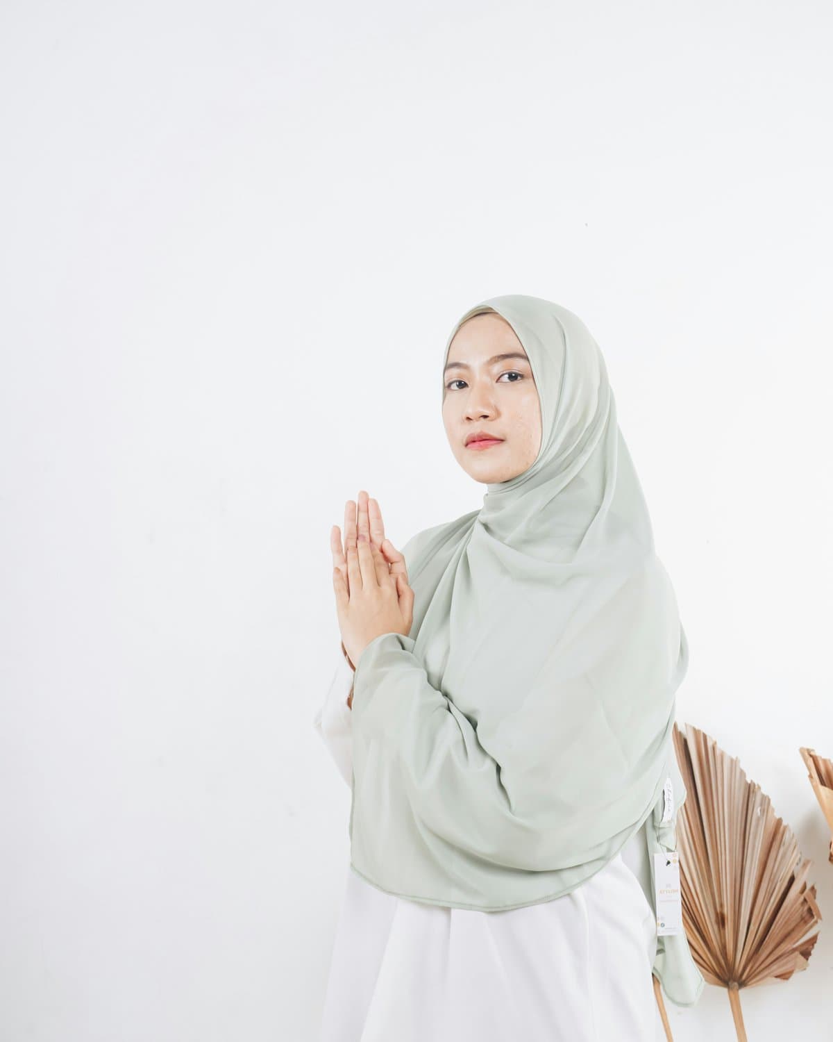 Woman wearing a soft sage green hijab outdoors
